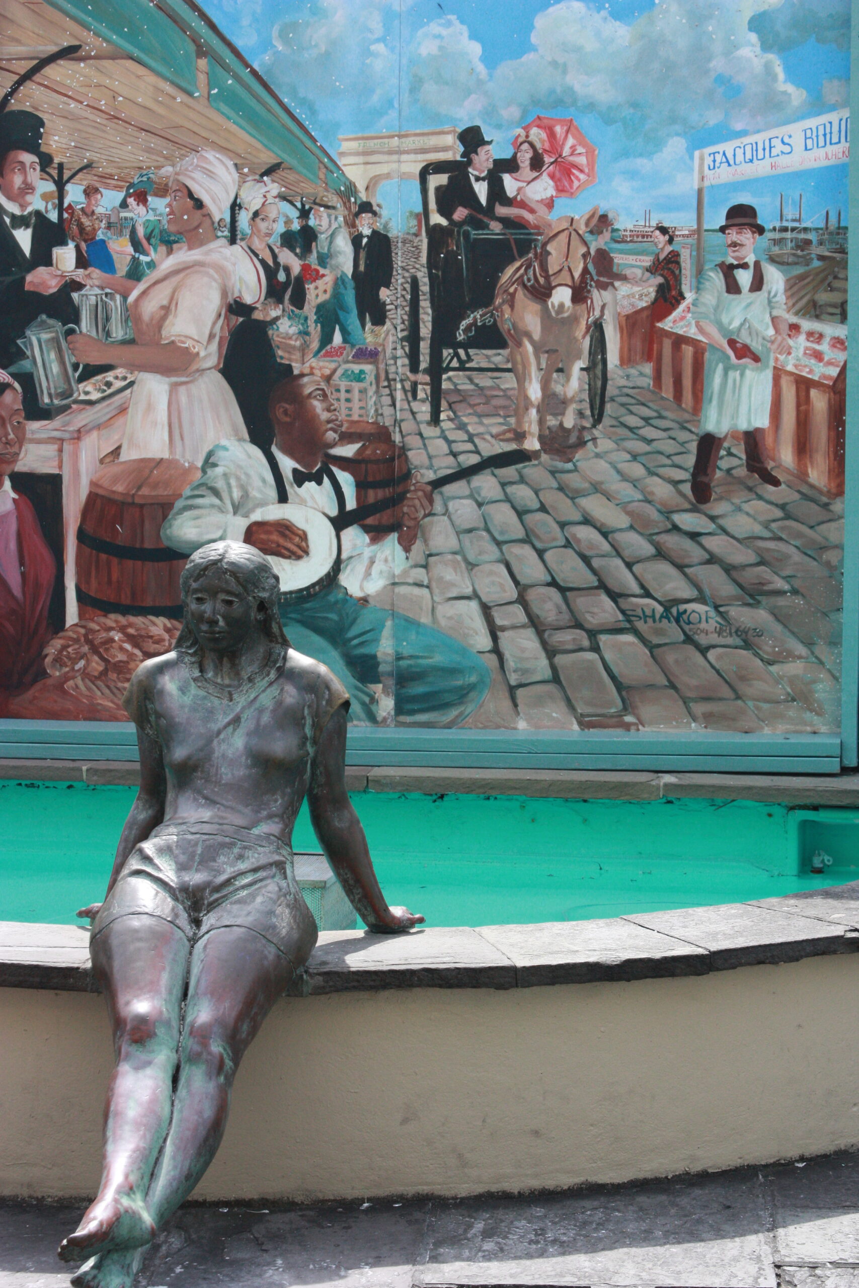 Estatua de bronce de una joven sentada frente a un mural vibrante que muestra un mercado antiguo con músicos, vendedores y un carruaje tirado por un caballo.