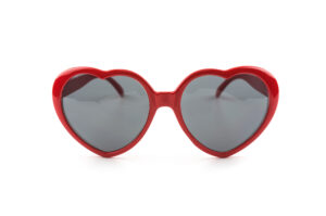 Gafas de sol rojas con forma de corazón sobre fondo blanco